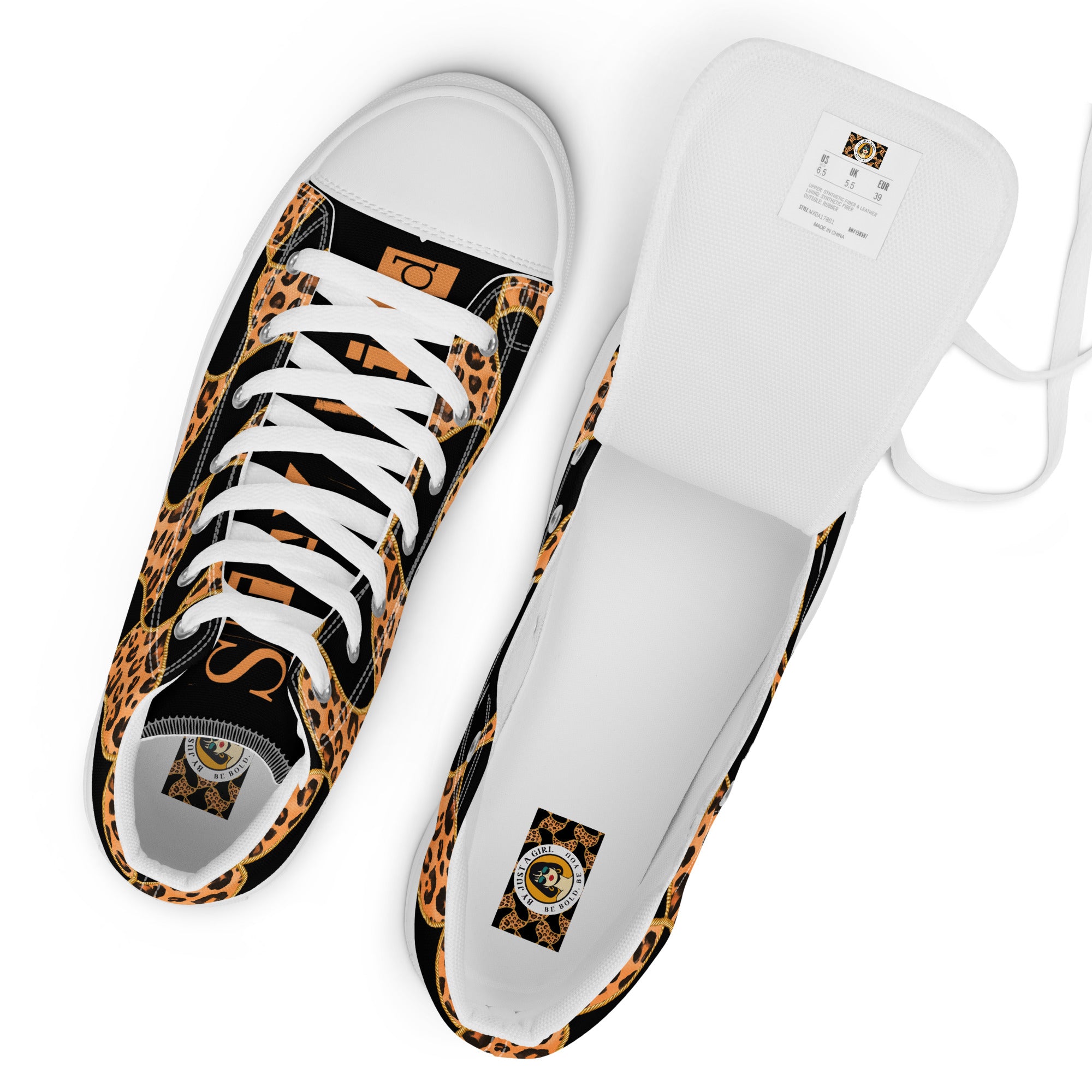 Ansicht von oben mit Sicht auf das Fussbett mit Logo der  High-Top-Canvas-Sneaker mit einem Muster aus Leopardenflecken und goldenen Kettenelementen auf schwarzem Hintergrund. Die schwarzen Schuhzungen tragen den Schriftzug "Stay Wild" in Leopardenmusterfarben. Sohlen, Zehenkappen und Schnürsenkel sind weiß. Designed, by Jsut a Girl.