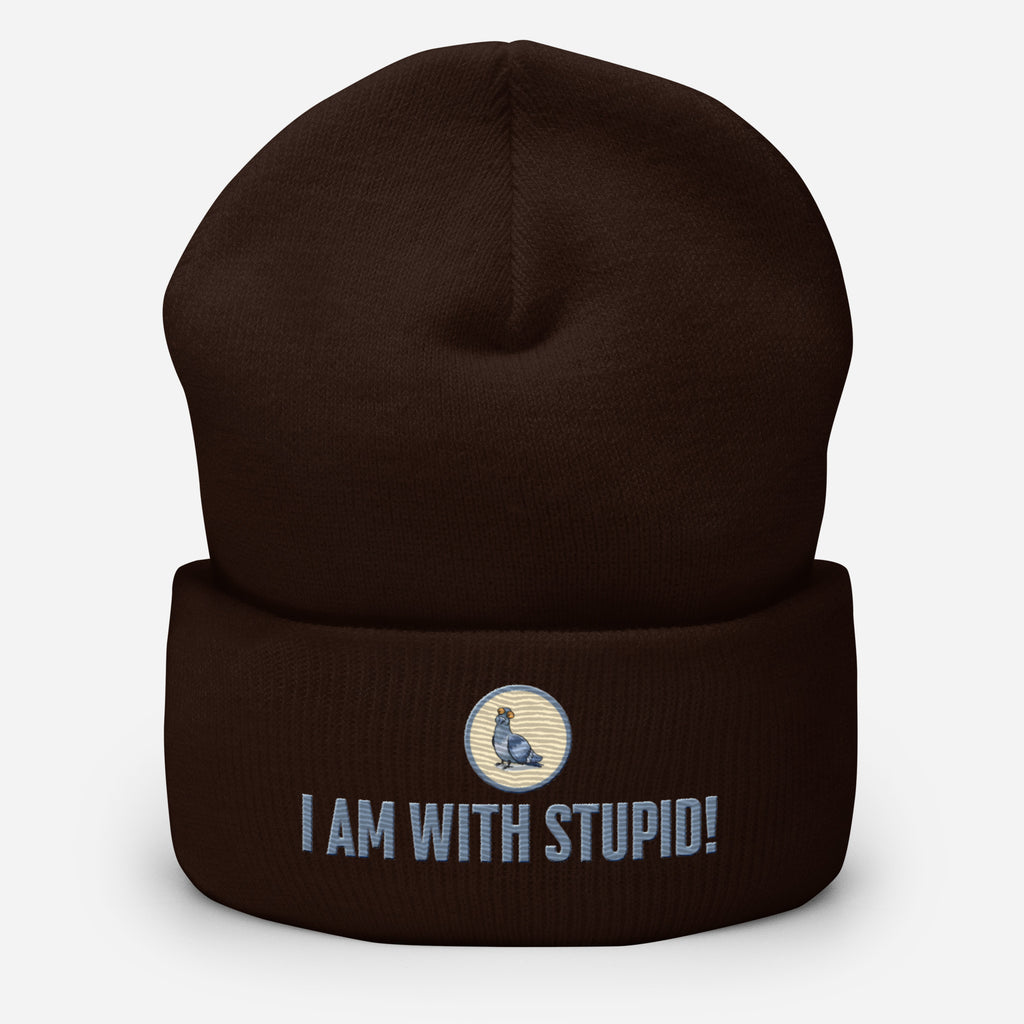 Eine Maroon farbene Cuffed Beanie mit aufgesticktem Patch als Taube mit einem runden beige-grauen Rahmen auf der Vorderseite. Darunter ein Schriftzug mit Grossgeschriebenen Buchstaben "I Am with Stupid!" Designed, by Just a Girl.