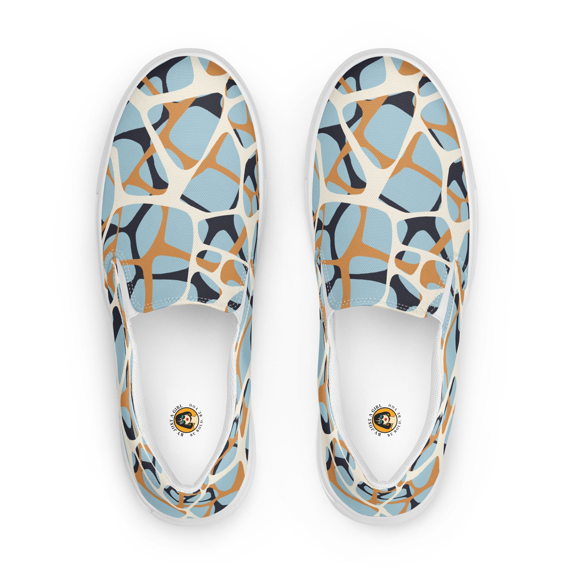 Ein Paar cremefarbener Slip-On Canvas Schuhe mit einem organischen, unregelmäßigen Muster in Hellblau, Orange und Dunkelgrau. Die Sohle ist weiß. Die Schuhe sind leicht nach links gedreht, sodass die Vorderseite beider Schuhe sichtbar ist.