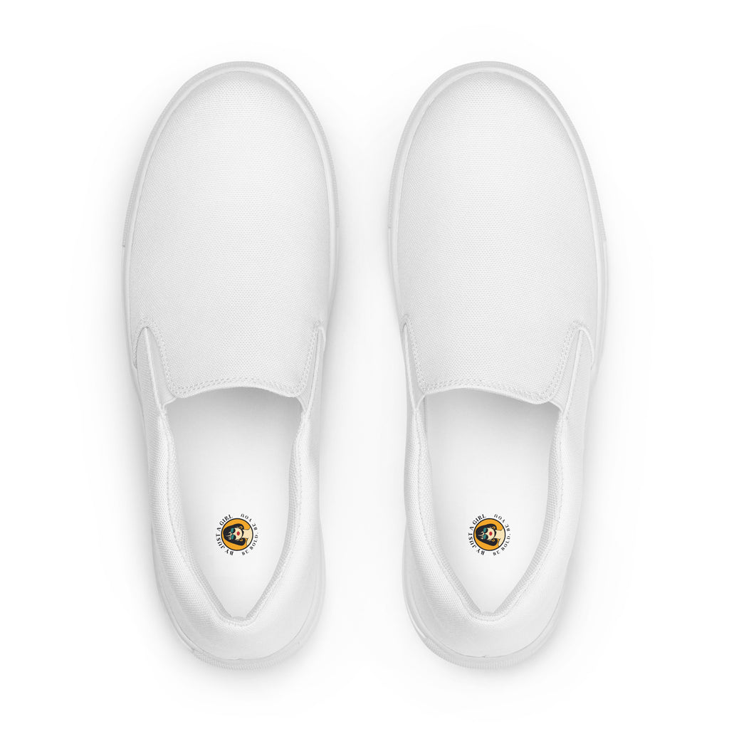 Ein Paar reinweißer Slip-On Canvas Schuhe, die auf einem weißen Hintergrund stehen. Die Schuhe sind schlicht und ohne Muster. Die Sohle ist ebenfalls weiß. Die Schuhe sind leicht nach links gedreht, sodass die Vorderseite beider Schuhe sichtbar ist.