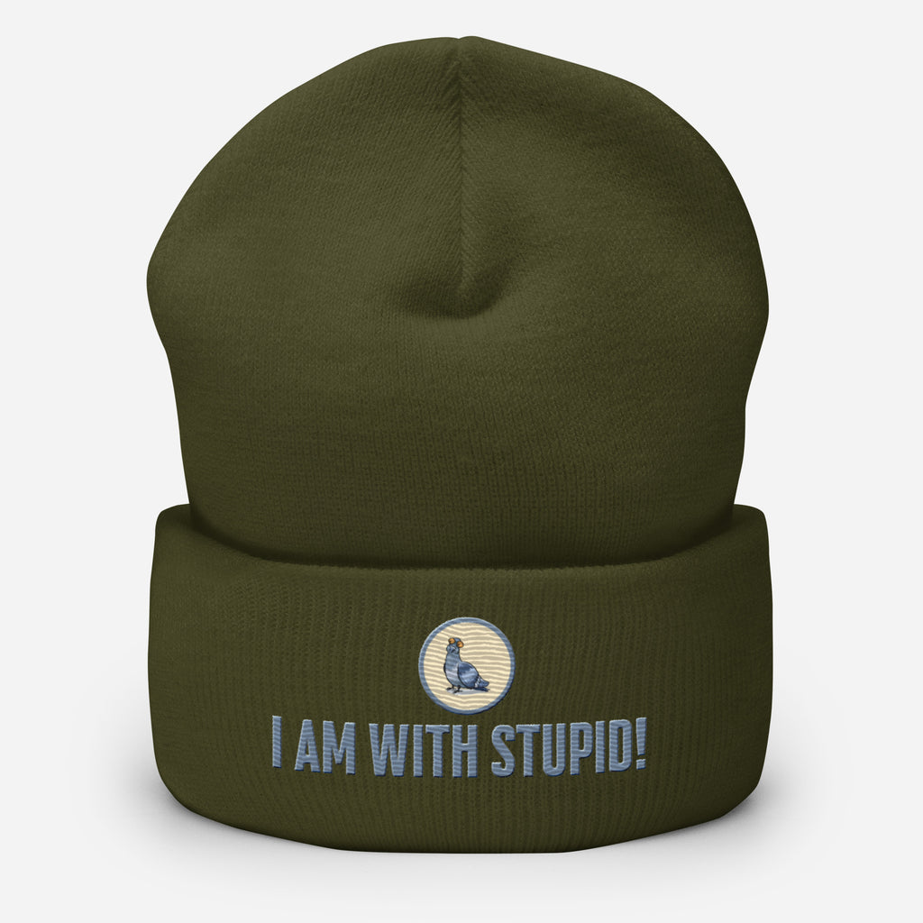 Eine Oliv farbene Cuffed Beanie mit aufgesticktem Patch als Taube mit einem runden beige-grauen Rahmen auf der Vorderseite. Darunter ein Schriftzug mit Grossgeschriebenen Buchstaben "I Am with Stupid!" Designed, by Just a Girl.