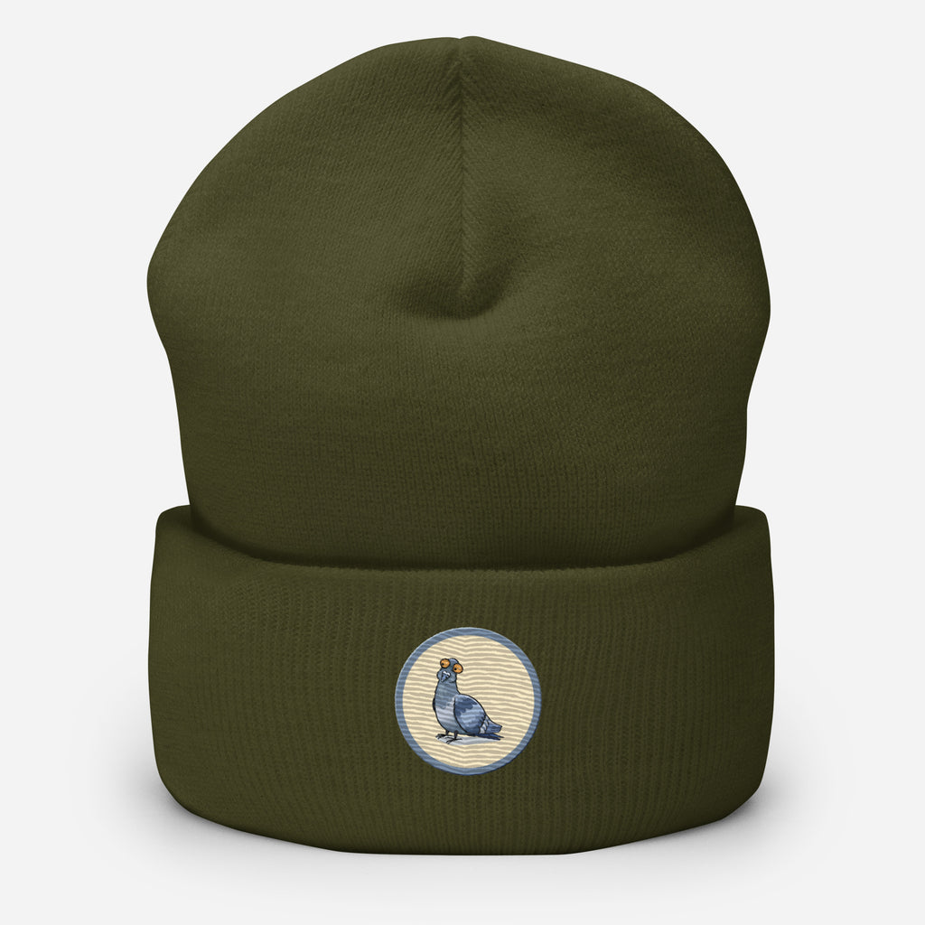 Eine Olivgrüne Cuffed Beanie mit aufgestckter Taube in einem grau-beigen rundem Rahmen auf der Vorderseite. Designed, by Just a Girl.
