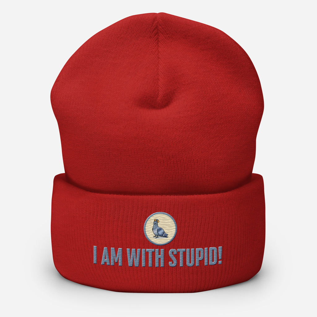 Eine Rote Cuffed Beanie mit aufgesticktem Patch als Taube mit einem runden beige-grauen Rahmen auf der Vorderseite. Darunter ein Schriftzug mit Grossgeschriebenen Buchstaben "I Am with Stupid!" Designed, by Just a Girl.