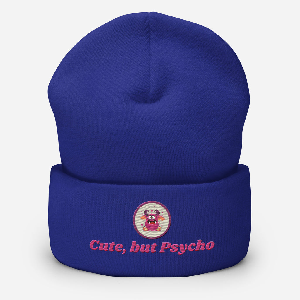 Eine Royal Blaue Cuffed Beanie mit aufgesticktem pinken monster gesicht in einem runden lila Rahmen auf der Vorderseite und "Cute but Psycho" Schrift darunter. Designed, by Just a Girl.