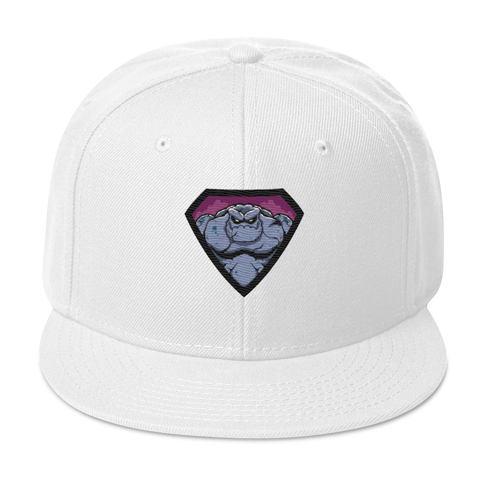 weiße Snapback Cap mit einem farbigen, grimmig aussehenden Monster- oder Felsenwesen-Emblem auf der Vorderseite.