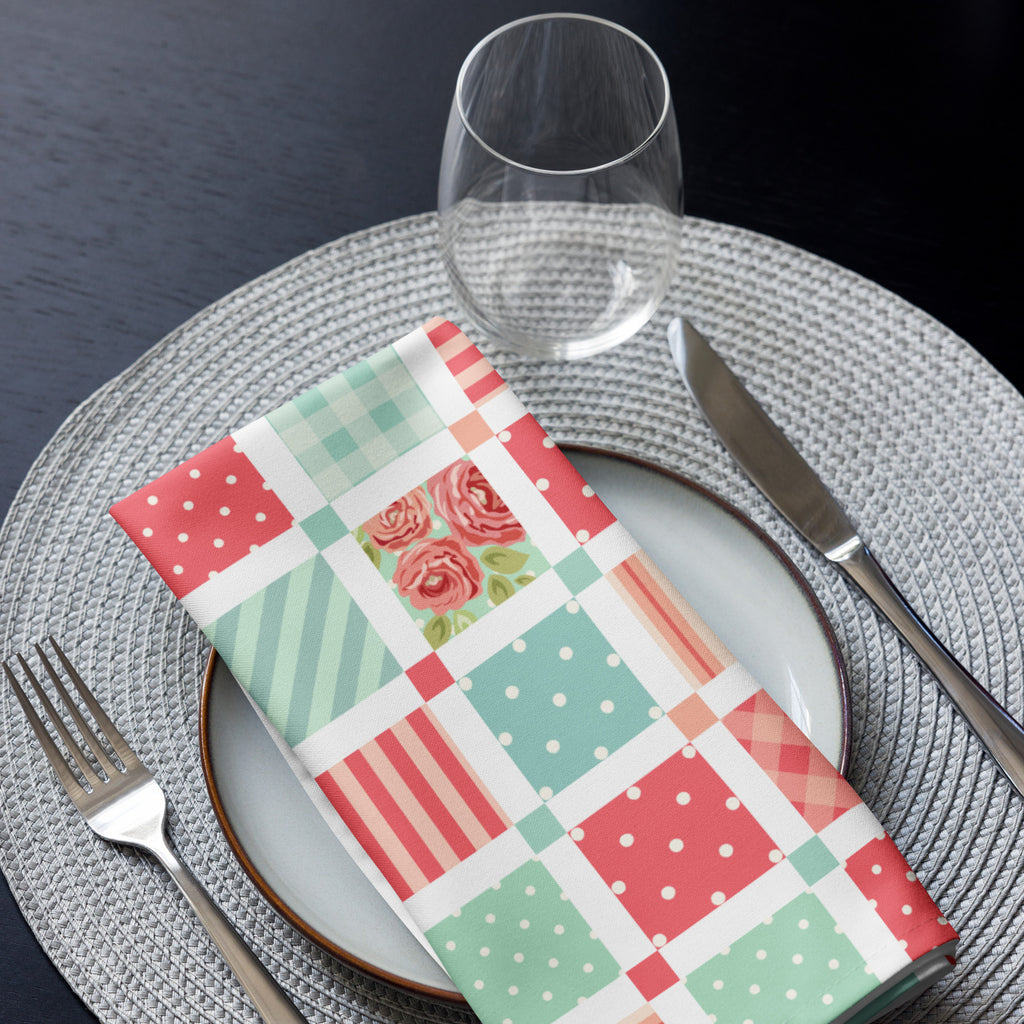 Eine Shabby Chic Stoff Serviette rechteckig gefaltet und auf einem Teller gelegt als Ansicht von oben als ein komplettes Tischgedeck.