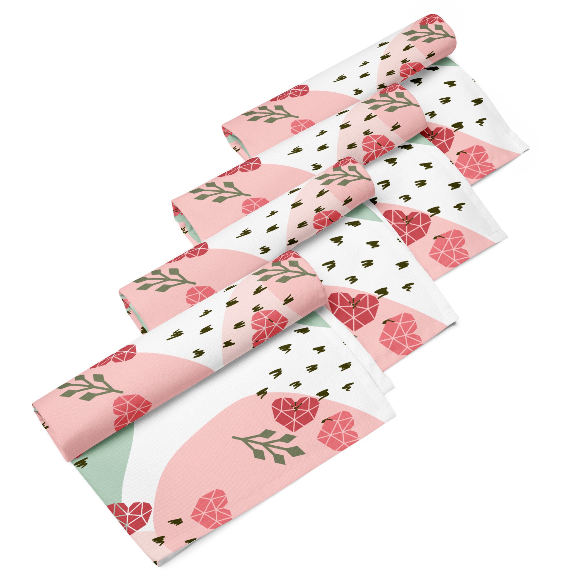Ein Set aus vier gerollten Stoff-Servietten, freigestellt auf weißem Hintergrund. Der Hintergrund ist weiß und zeigt ein abstraktes Muster mit rosafarbenen Herzen, hellgrünen Blattformen und kleinen schwarzen Strichen.