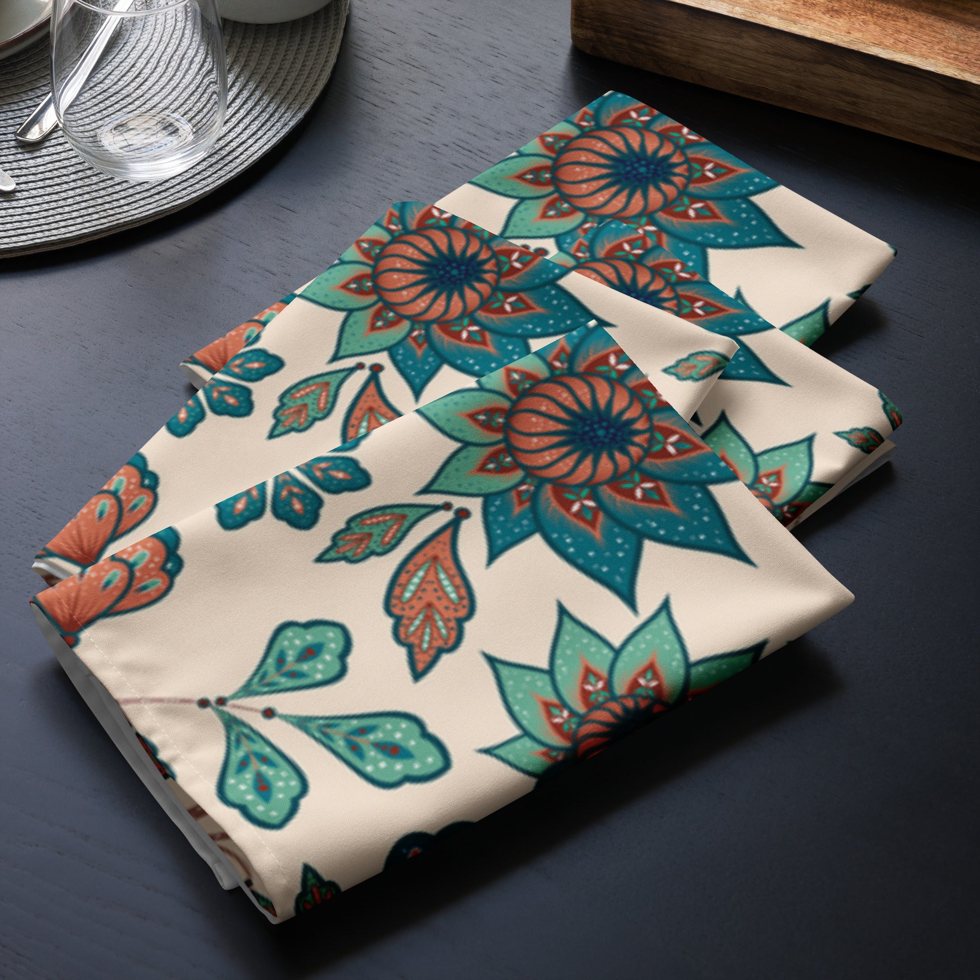 4er Set Stoff Servietten gefaltet auf dem Tisch platziert. Der Hintergrund der Servietten ist Beige und zeigt ein ornamentales Muster aus stilisierten Vögeln, die auf floralen Zweigen mit Blumen und Blättern sitzen. Die Motive sind in Türkis-, Rostrot- und Brauntönen gehalten.