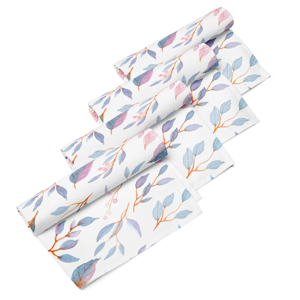 Ein Set aus vier gerollte Stoff-Servietten, freigestellt auf weißem Hintergrund. Der Hintergrund der Servietten ist weiß und zeigt ein filigranes Muster aus Zweigen mit Blättern und kleinen Beeren. Die Blätter sind in zarten Blau-, Lila- und Rosatönen gehalten, während die Beeren dunkelblau sind.