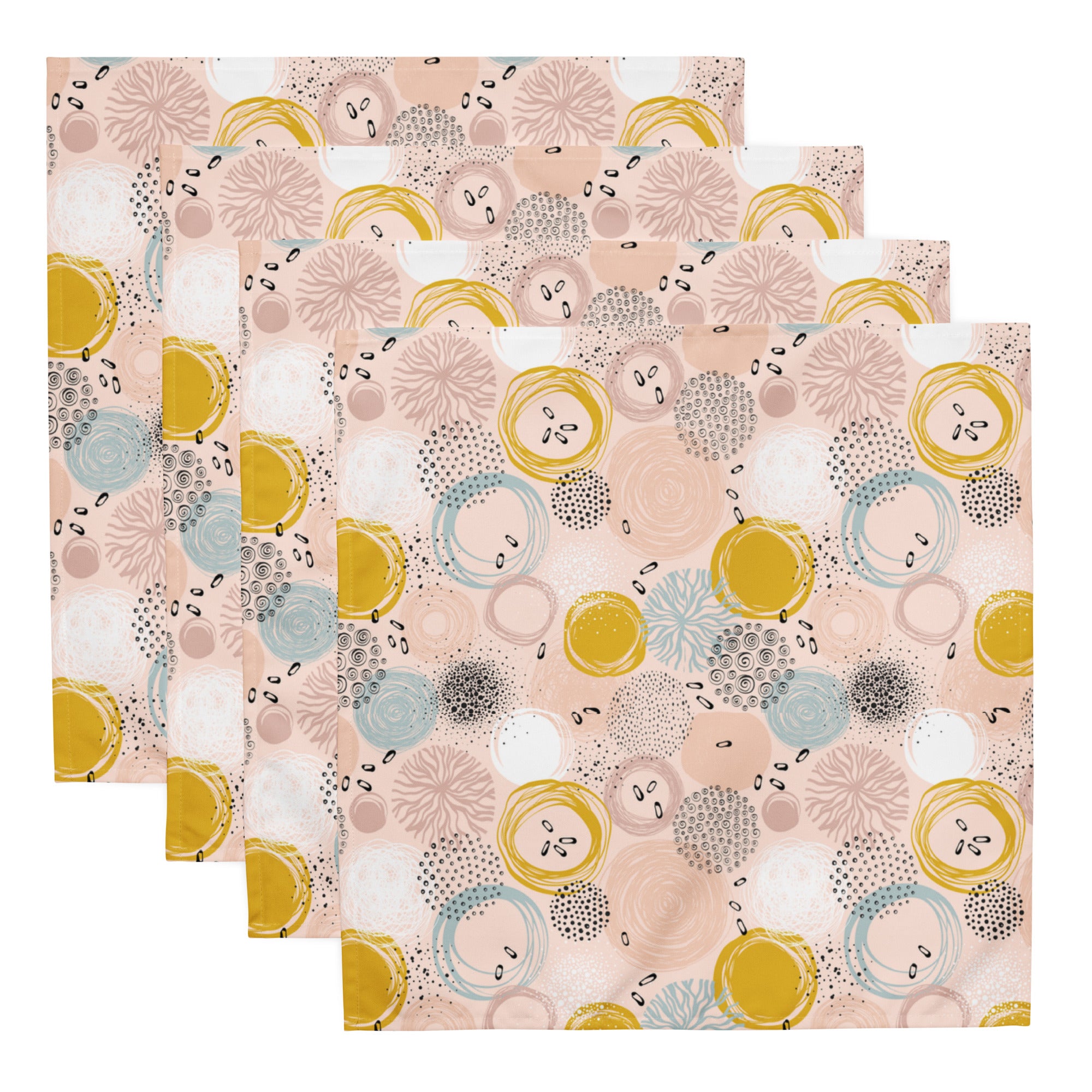 Ein Set aus vier Stoff-Servietten, freigestellt auf weißem Hintergrund. Die Servietten haben einen rosafarbenen Hintergrund und zeigen ein abstraktes Muster aus Kreisen in Gelb, Blau und Weiß sowie kleine schwarze Sprenkel.