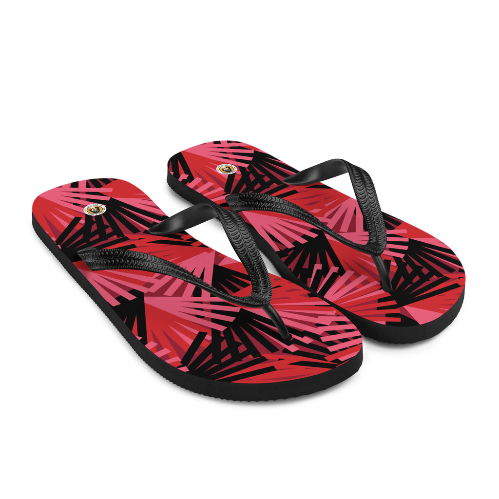 Ein Paar schwarze Herren-Flip-Flops mit einem Obermaterial, das ein komplexes, fächerartiges und geometrisches Muster in verschiedenen Rottönen (von Hellrot bis Dunkelrot) und Schwarz zeigt. Die Formen scheinen aus einem Mittelpunkt zu explodieren oder sich aufzufächern. Die Riemen sind schwarz und haben eine strukturierte Oberfläche.