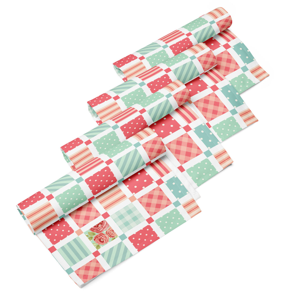 Ein 4er Set Stoff-Servietten im Shabby Chic Stil, fotografiert auf weißem Hintergrund. Das Patchwork-Muster besteht aus quadratischen Feldern mit floralen Rosenmotiven, Streifen, kleinen Punkten und Karos in zarten Pastellfarben wie Rosa und Mintgrün.