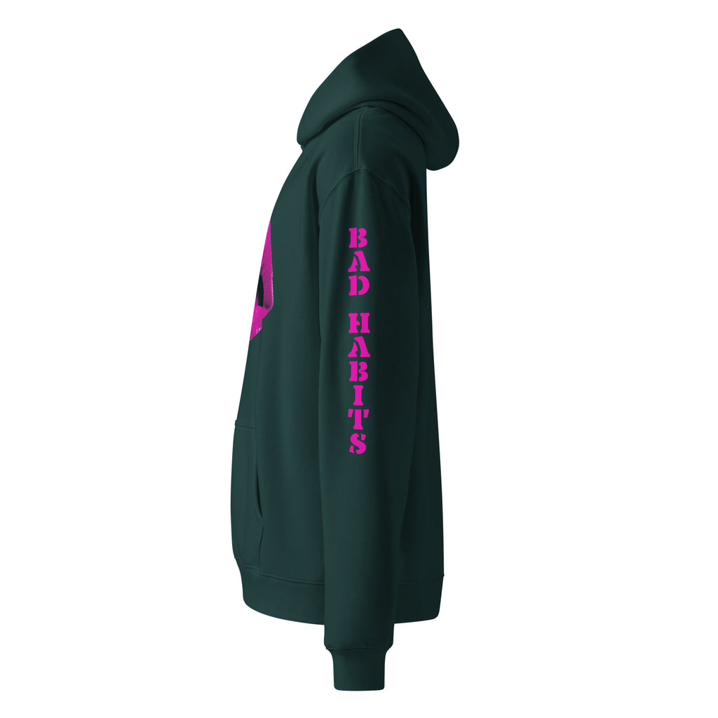 Oversized Hoodie in piniengrün mit "Bad Habits" in pinken Design. Verfügt über ein Mund-Motiv auf der Vorderseite und einen "BAD HABITS" Schriftzug auf dem Ärmel. Erhältlich in 4 verschiedenen Farben.