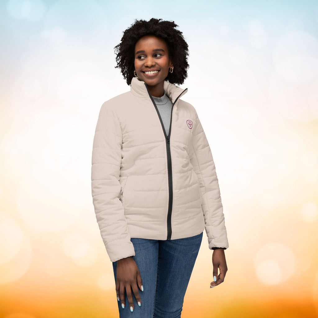 Ein weibliches Model trägt eine Damen-Pufferjacke in einem zarten Champagner-Rosa. Die Jacke ist horizontal gesteppt, hat eine glatte Oberfläche, einen hohen Stehkragen und einen durchgehenden Reißverschluss. Designed, by Just a Girl.