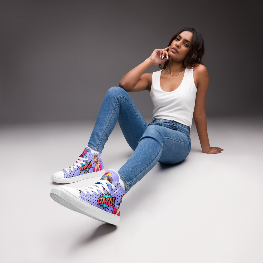 Ein weibliches Model trägt die High-Top-Canvas-Sneaker im Pop-Art-Stil. Der Schuh hat einen lila Hintergrund mit schwarzen Punkten, eine Comic-Frau und eine "OMG!"-Sprechblase. Die linke Schuhzunge zeigt ein Superman-Logo und eine "OK!"-Sprechblase, die rechte Zunge eine "Yesss!"-Sprechblase. Sohlen, Zehenkappen und Schnürsenkel sind weiß. Designed, by Just a Girl.