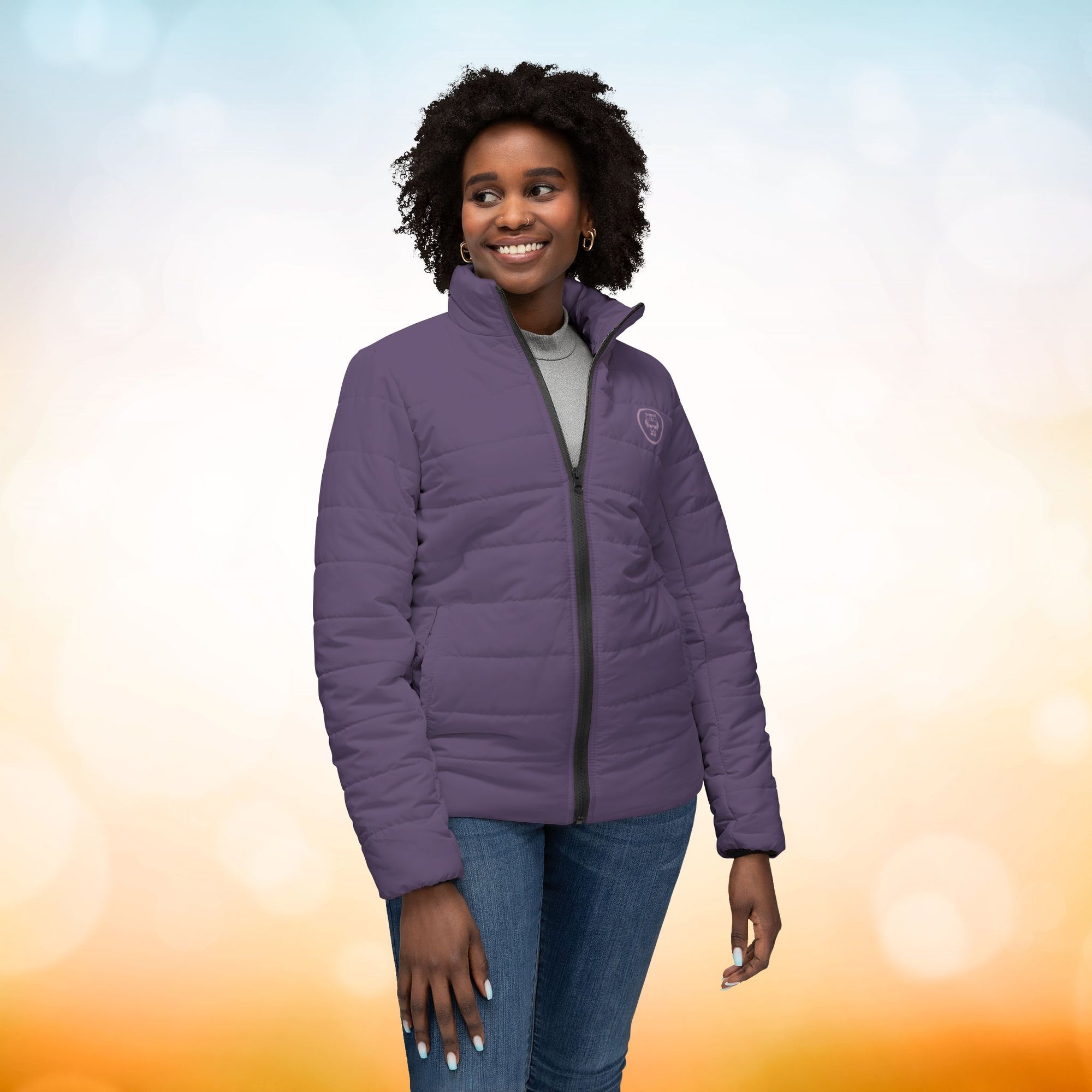 Ein weibliches Model trägt eine Damen-Pufferjacke in einem dunklem Dusty Plum Farbton. Die Jacke ist horizontal gesteppt, hat eine glatte Oberfläche, einen hohen Stehkragen und einen durchgehenden Reißverschluss. Das Model präsentiert sich von der Vorderseite. Designed, by Just a Girl.