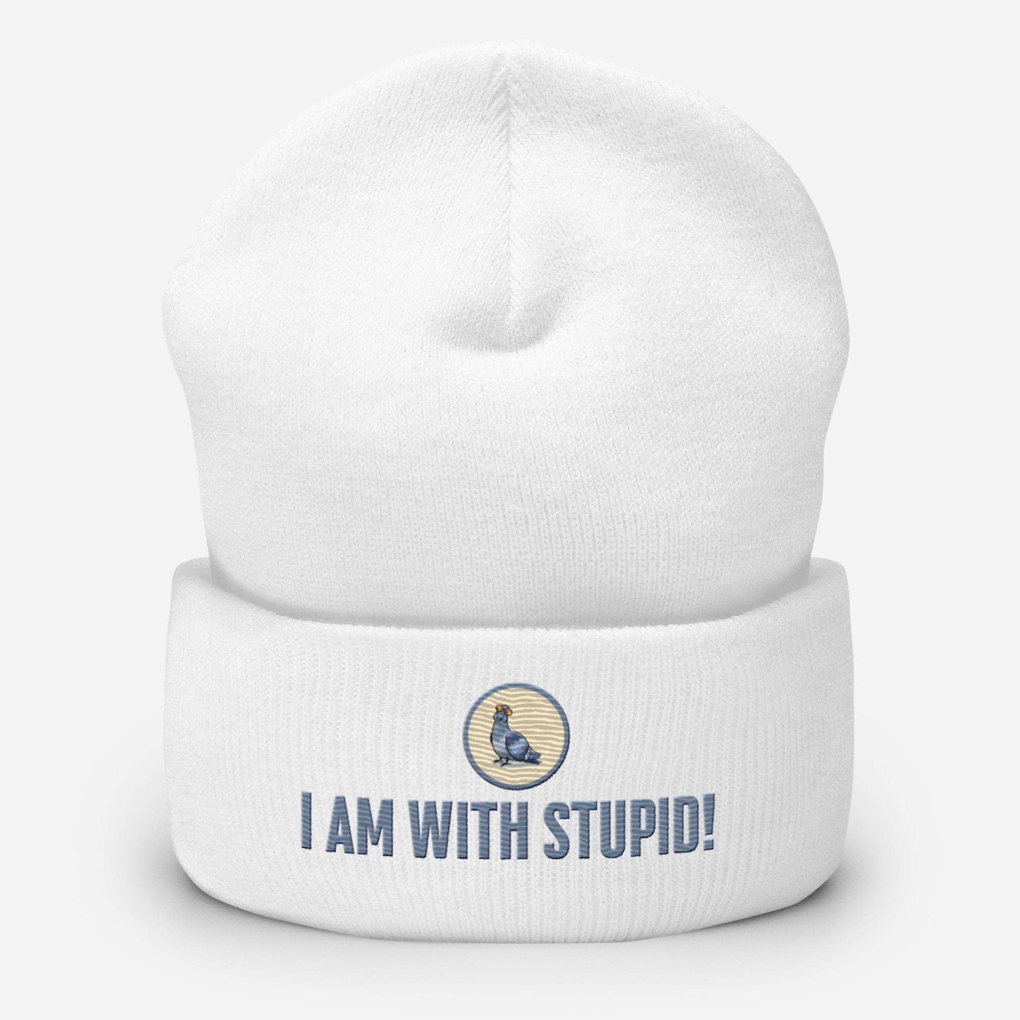 Eine weiße Cuffed Beanie mit aufgesticktem Patch als Taube mit einem runden beige-grauen Rahmen auf der Vorderseite. Darunter ein Schriftzug mit Grossgeschriebenen Buchstaben "I Am with Stupid!" Designed, by Just a Girl.