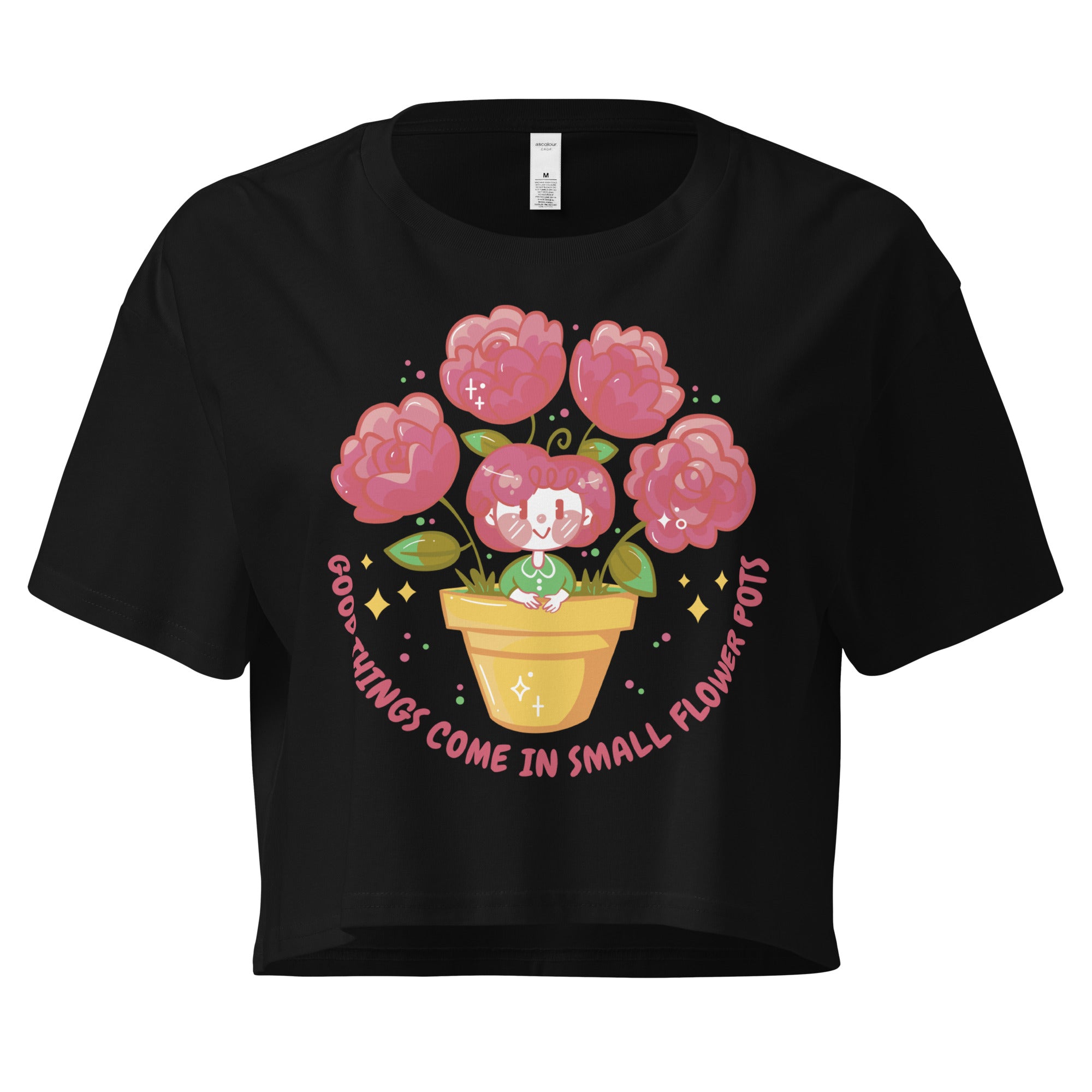 Ein schwarzes kurz geschnittenes Damen-T-Shirt (Crop Top) mit einer Illustration einer kleinen, lächelnden Figur in einem gelben Blumentopf. Um den Blumentopf herum sind mehrere große, rosa Blüten und grüne Blätter. Der Text "GOOD THINGS COME IN SMALL FLOWER POTS" ist in einem Bogen um das Motiv herum angeordnet, mit kleinen Sternen und Punkten.