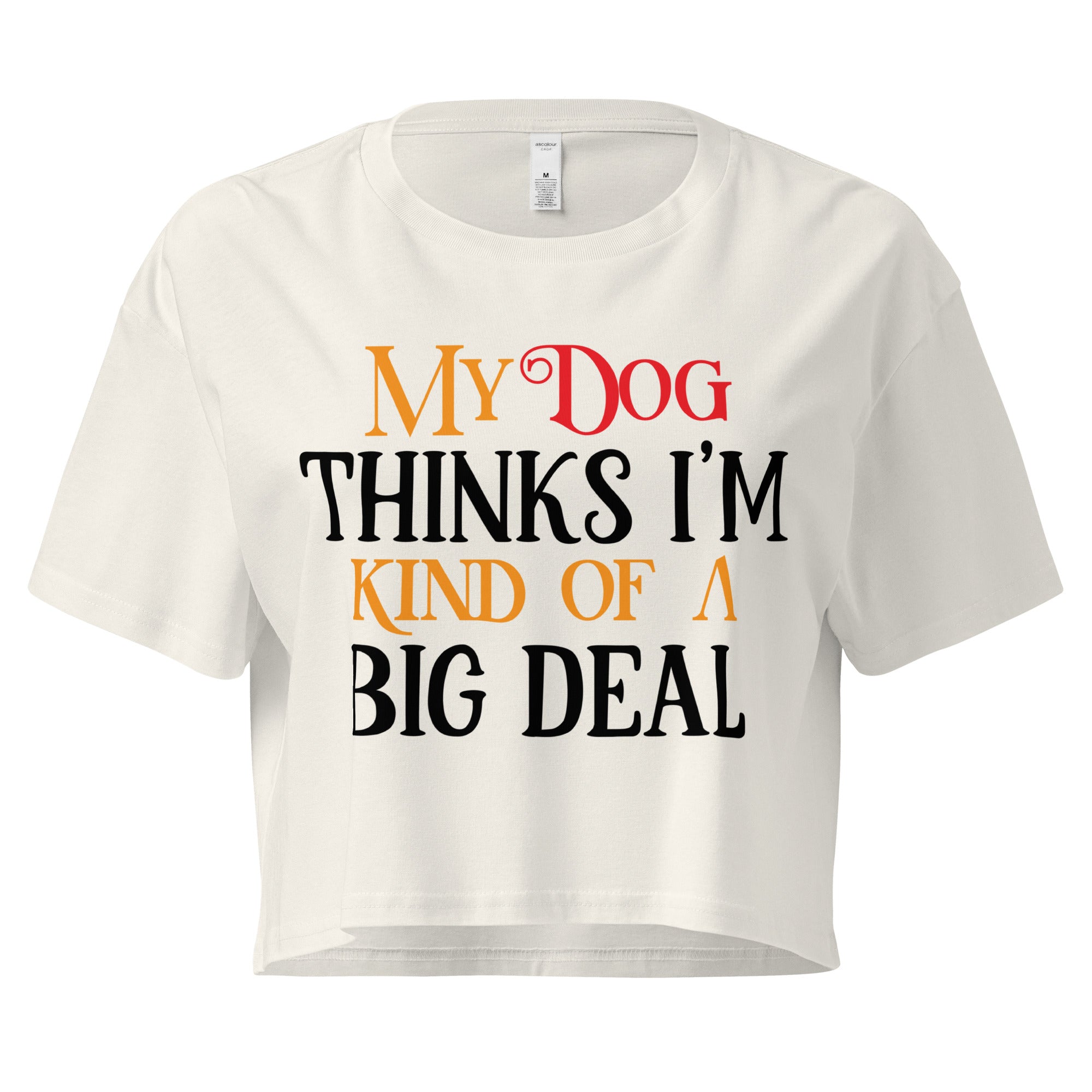 Ein ecrufarbenes, kurz geschnittenes Damen-T-Shirt (Crop Top) mit dem Text "My Dog THINKS I'M KIND OF A BIG DEAL". Die Wörter "Dog" und "A" sind in Rot, "KIND OF" und "BIG" in Orange, und der restliche Text in Schwarz gehalten.