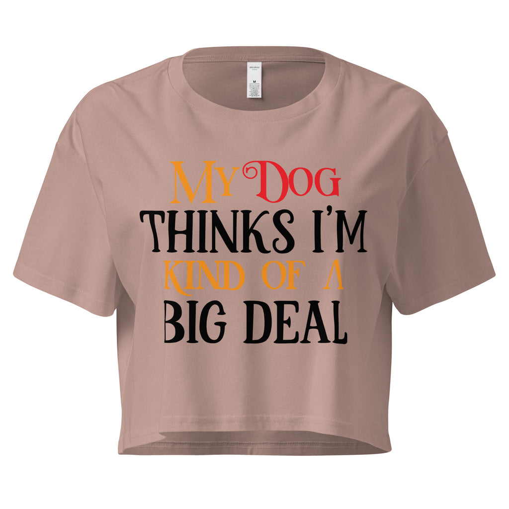 Ein hazy pinkfarbenes, kurz geschnittenes Damen-T-Shirt (Crop Top) mit dem Text "My Dog THINKS I'M KIND OF A BIG DEAL". Die Wörter "Dog" und "A" sind in Rot, "KIND OF" und "BIG" in Orange, und der restliche Text in Schwarz gehalten.