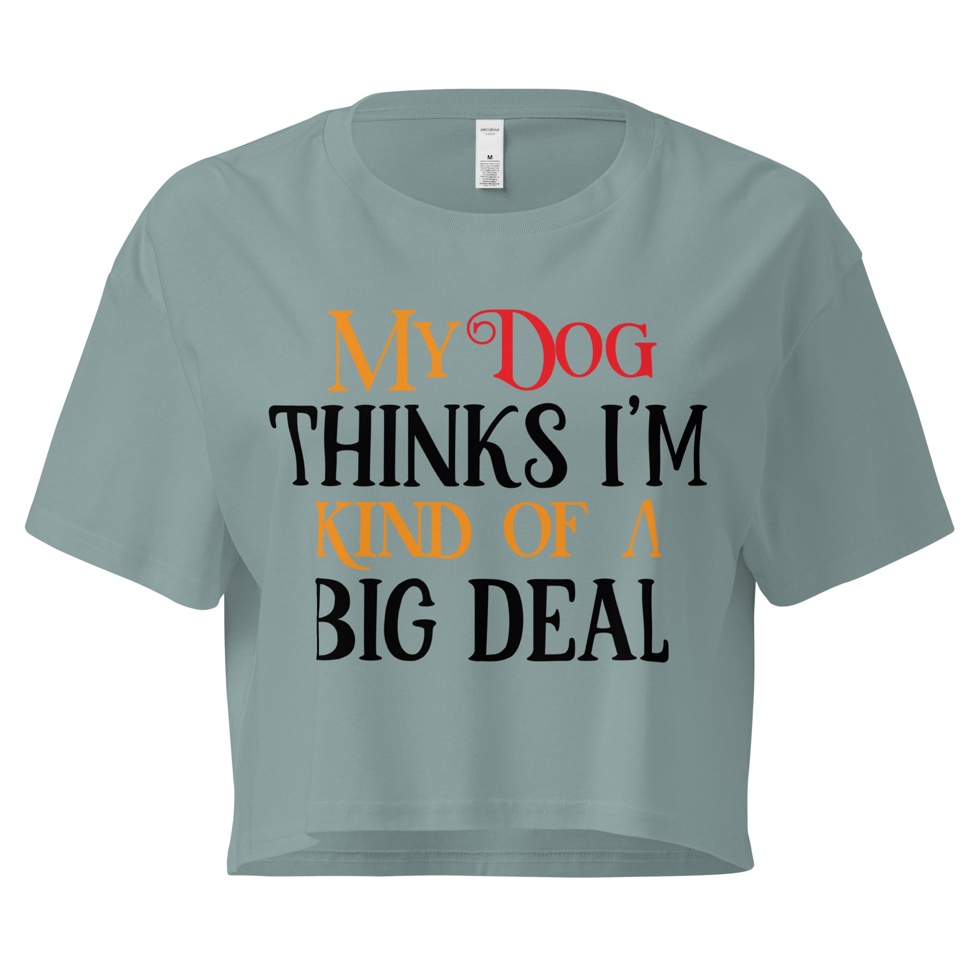 Ein mineralfarbenes, kurz geschnittenes Damen-T-Shirt (Crop Top) mit dem Text "My Dog THINKS I'M KIND OF A BIG DEAL". Die Wörter "Dog" und "A" sind in Rot, "KIND OF" und "BIG" in Orange, und der restliche Text in Schwarz gehalten.