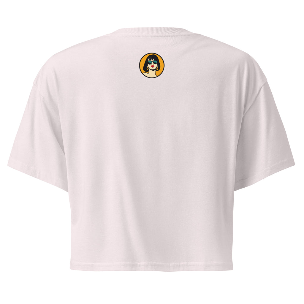 Ein orchid farbenes kurz geschnittenes Damen-T-Shirt (Crop Top) mit einer Illustration einer kleinen, lächelnden Figur in einem gelben Blumentopf. Um den Blumentopf herum sind mehrere große, rosa Blüten und grüne Blätter. Der Text "GOOD THINGS COME IN SMALL FLOWER POTS" ist in einem Bogen um das Motiv herum angeordnet, mit kleinen Sternen und Punkten.