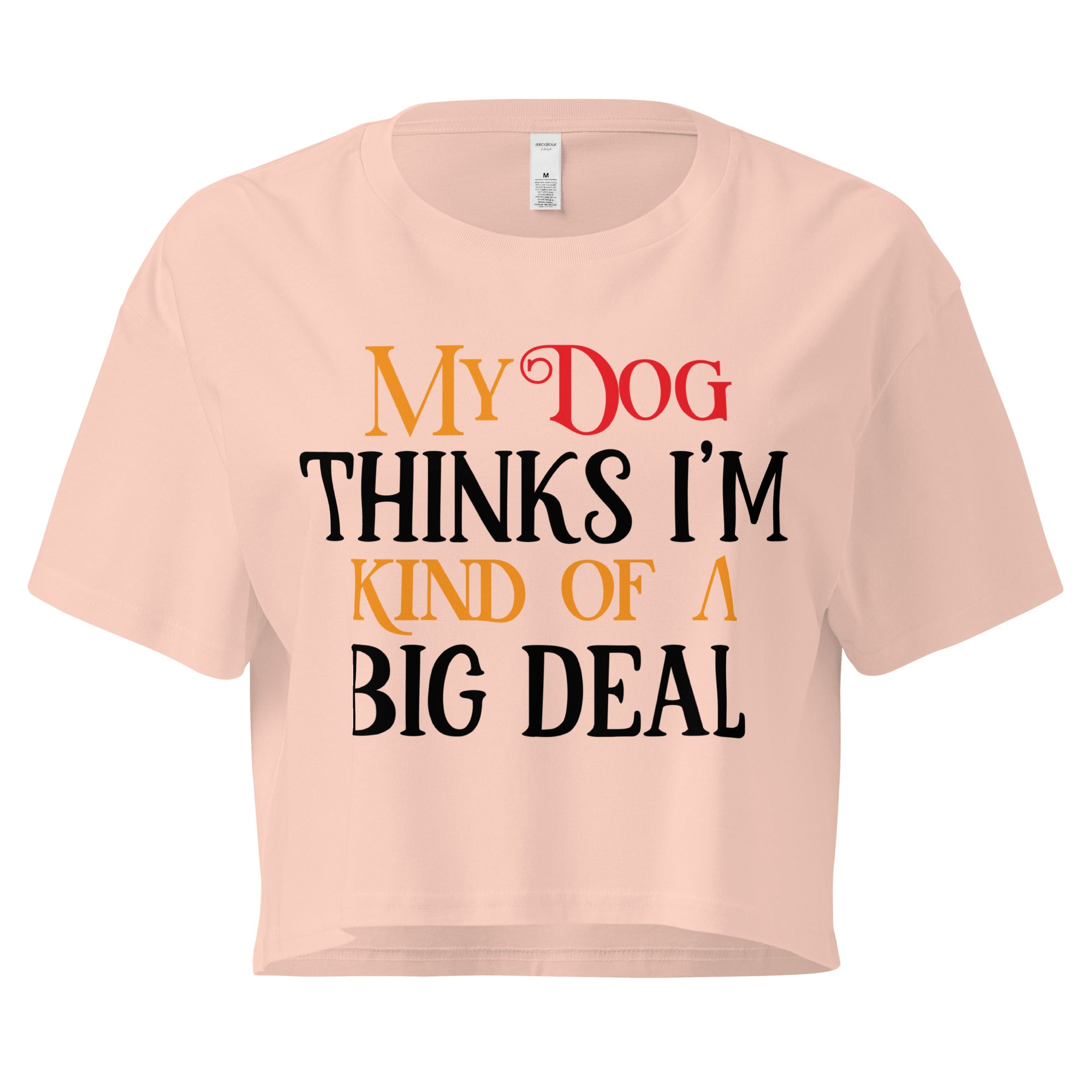 Ein pale pink farbenes, kurz geschnittenes Damen-T-Shirt (Crop Top) mit dem Text "My Dog THINKS I'M KIND OF A BIG DEAL". Die Wörter "Dog" und "A" sind in Rot, "KIND OF" und "BIG" in Orange, und der restliche Text in Schwarz gehalten.