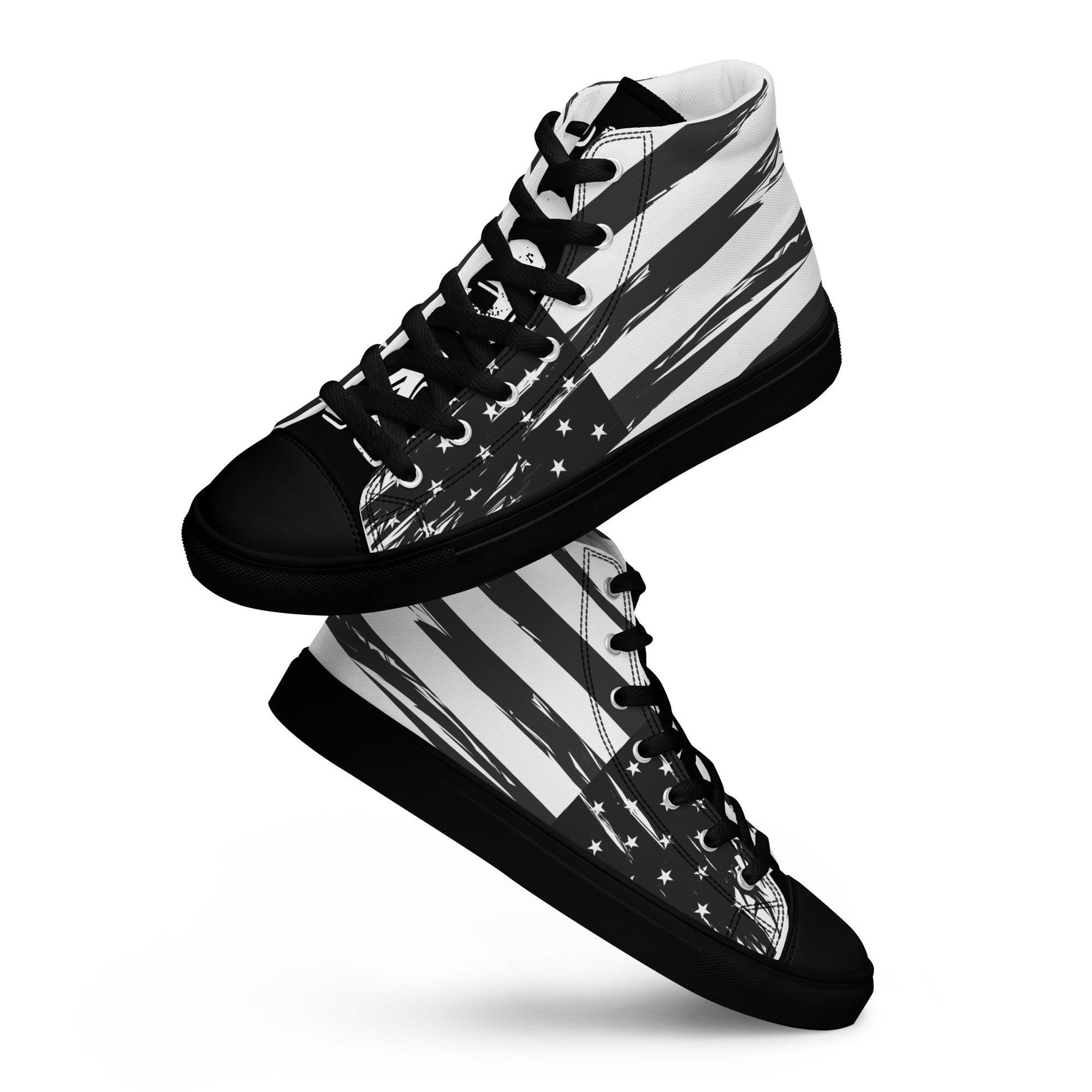 Ein Paar schwarze schwebende High-Top Canvas Schuhe mit einem Schwarz-Weiß-Design, das an die USA-Flagge erinnert. Beide Schuhe haben eine schwarze Schuhzunge; die linke trägt den weißen College-Schriftzug "USA" und die rechte vier weiße doppelten Sterne. Die Schuhsohle, Fusskappe und Schnürsenkel sind schwarz. Designed, by Just a Girl.