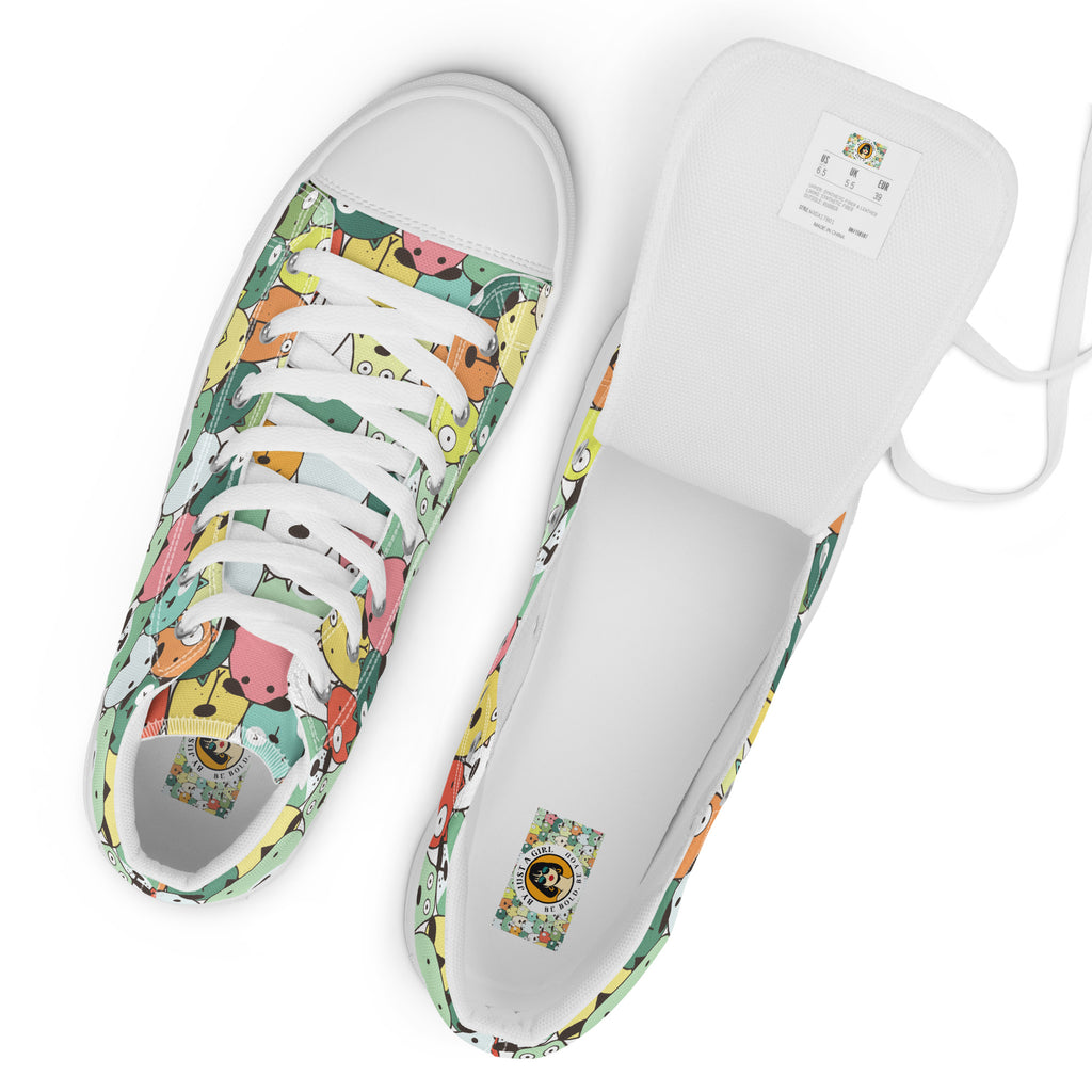 Ansicht von oben der weißen High-Top-Sneaker mit einem dichten, sich wiederholenden Muster aus stilisierten, farbenfrohen Cartoon-Köpfen von Tieren oder fantastischen Kreaturen in Tönen wie Gelb, Grün, Rosa, Orange und Hellblau. Die Schnürsenkel und Zehenkappen sind weiß. Designed, by Just a Girl.
