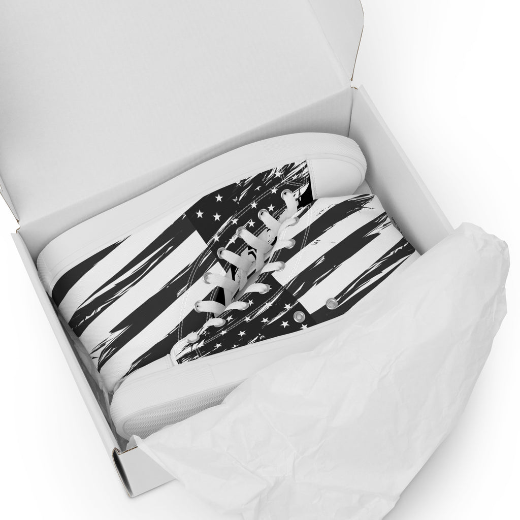 Ein Paar High-Top Canvas Schuhe Ansicht liegend im Schuhkarton mit einem Schwarz-Weiß-Design, das an die USA-Flagge erinnert.  Die Schuhsohle, Fusskappe und Schnürsenkel sind weiß. Designed, by Just a Girl.