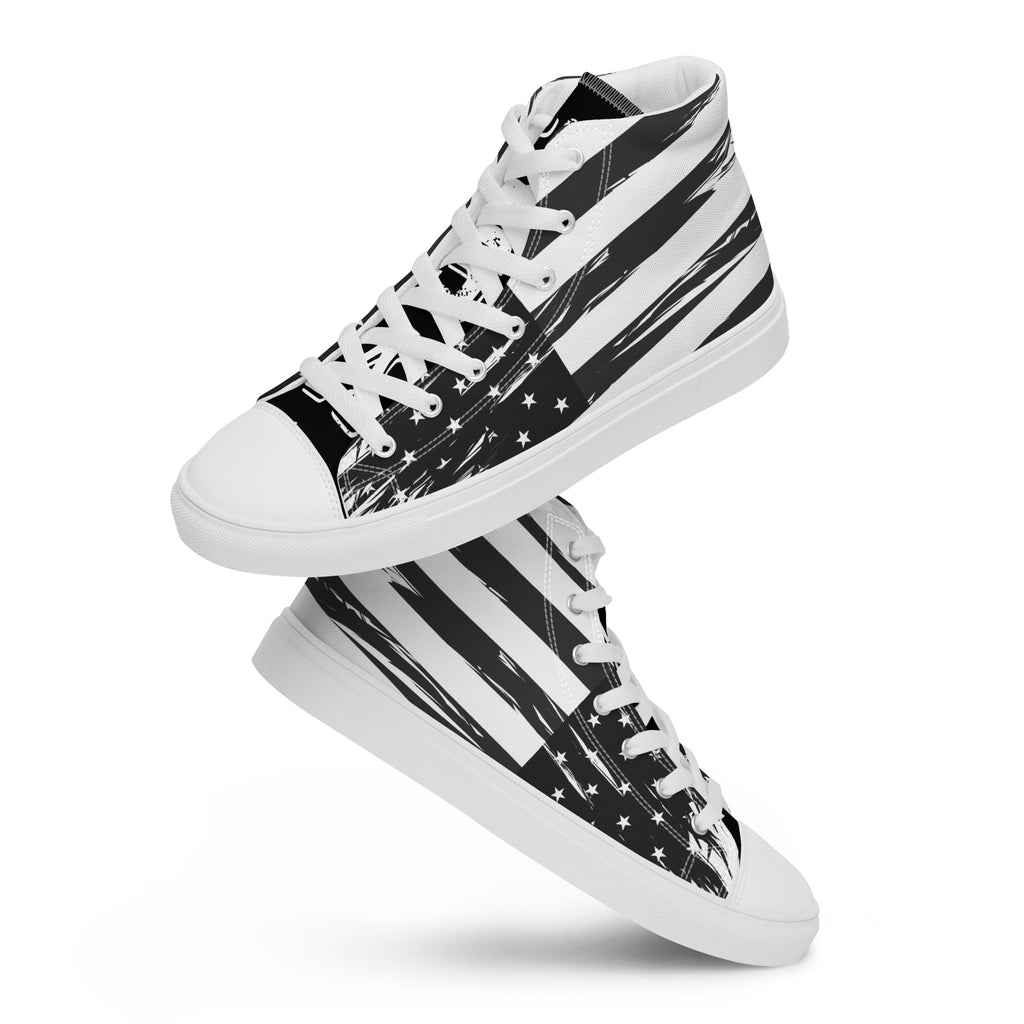 Ein Paar schwebende High-Top Canvas Schuhe mit einem Schwarz-Weiß-Design, das an die USA-Flagge erinnert. Beide Schuhe haben eine schwarze Schuhzunge; die linke trägt den weißen College-Schriftzug "USA" und die rechte vier weiße doppelten Sterne. Designed, by Just a Girl.