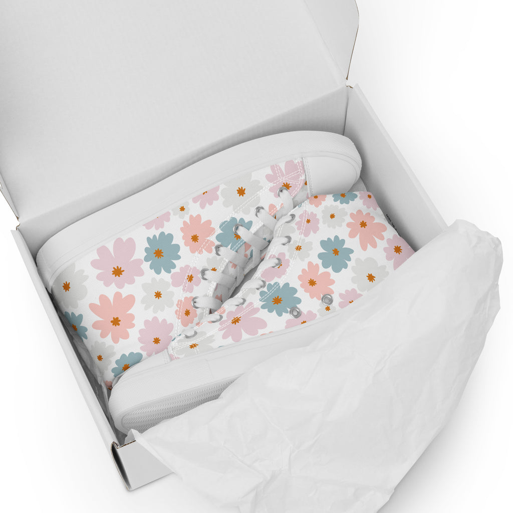 Ansicht 2 weiße High-Top-Sneaker mit einem Blumenmuster in Pastellfarben (Rosa, Apricot, beige und petrolfaben). Die Schnürsenkel und Zehenkappen sind weiß, liegend im Schuhkarton. Designed, by Just a Girl.