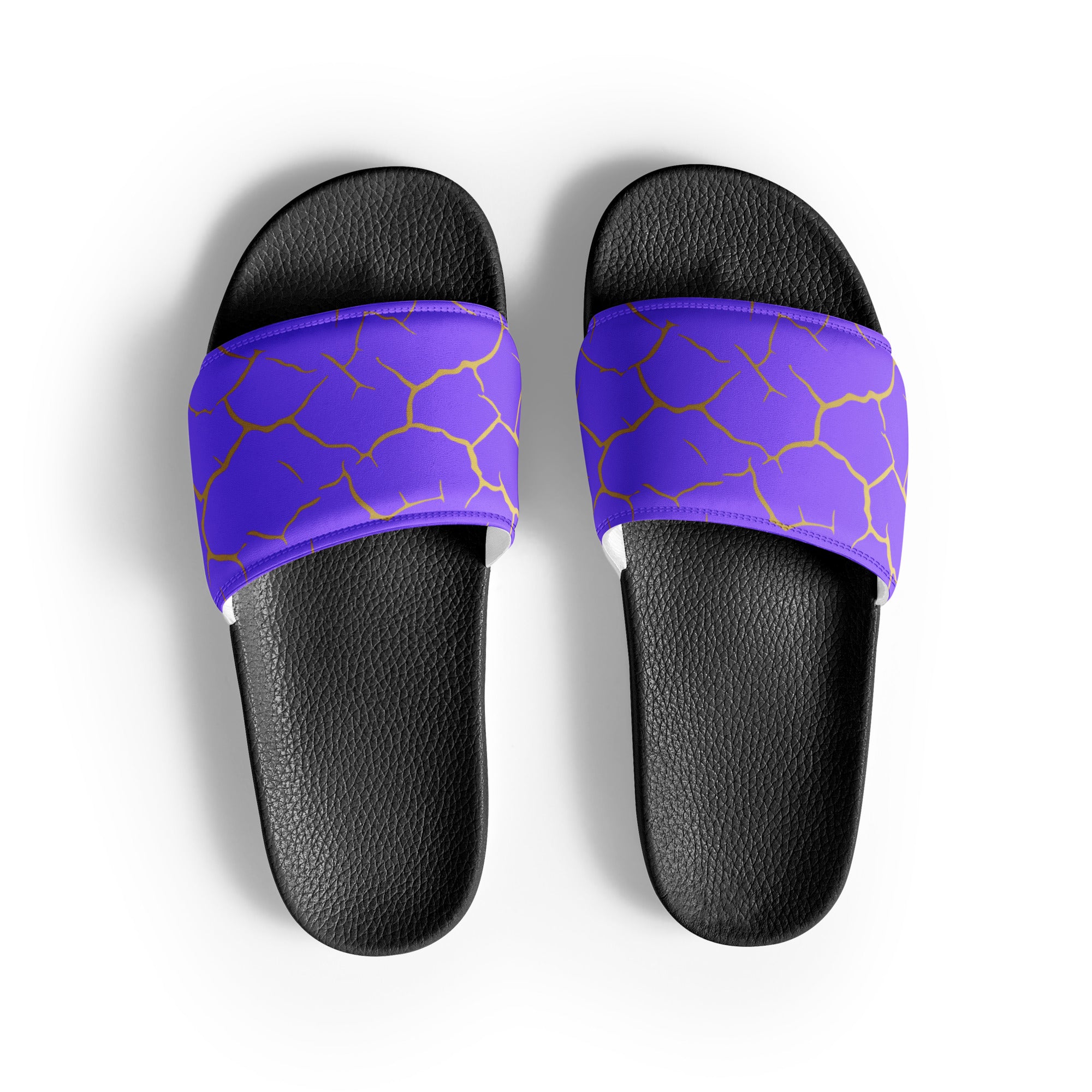 Ein Paar schwarze Flip-Flops mit einem Obermaterial in einem kräftigen Violett, das von einem unregelmäßigen Muster aus gebrochenen goldenen Linien durchzogen ist, die wie Risse oder Sprünge aussehen. Die Riemen sind schwarz und haben eine strukturierte Oberfläche. Auf der Ferse jedes Flip-Flops befindet sich ein rundes gelbes Emblem mit dem Text "BY JUST A GIRL" und "BE BOLD. BE YOU" sowie dem stilisierten Kopf einer Frau mit Bob-Frisur und Sonnenbrille.