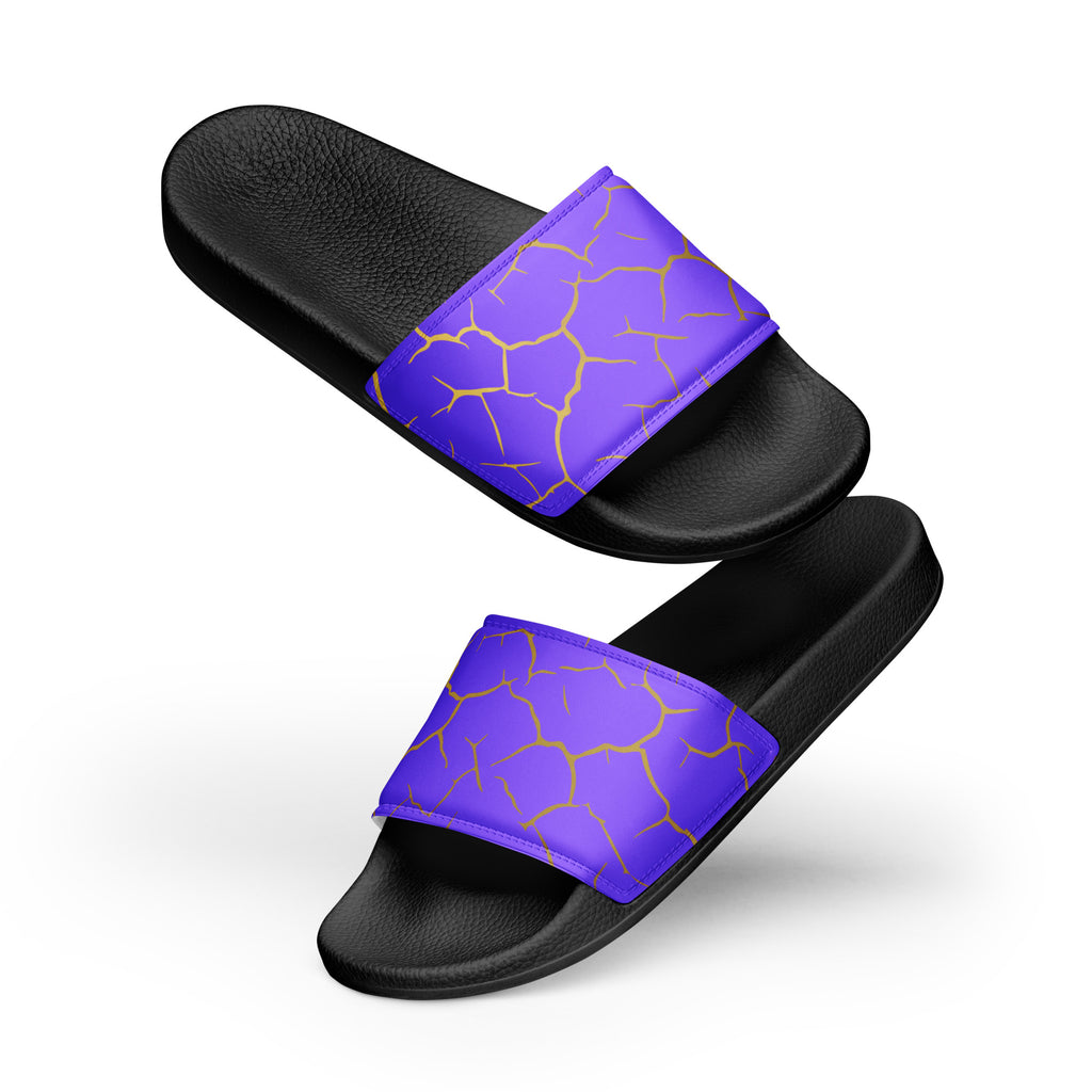 Ein Paar schwarze Flip-Flops mit einem Obermaterial in einem kräftigen Violett, das von einem unregelmäßigen Muster aus gebrochenen goldenen Linien durchzogen ist, die wie Risse oder Sprünge aussehen. Die Riemen sind schwarz und haben eine strukturierte Oberfläche. Auf der Ferse jedes Flip-Flops befindet sich ein rundes gelbes Emblem mit dem Text "BY JUST A GIRL" und "BE BOLD. BE YOU" sowie dem stilisierten Kopf einer Frau mit Bob-Frisur und Sonnenbrille.

